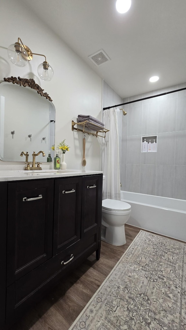 bathroom featuring visible vents, toilet, shower / bathtub combination with curtain, wood finished floors, and vanity