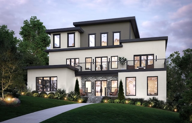 rear view of property featuring stucco siding, a yard, and a balcony