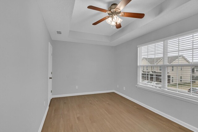 3031 Rg Buchanan Dr, La Vergne, TN 37086 - empty room with wood finished floors, ceiling fan, baseboards, visible vents, and a raised ceiling