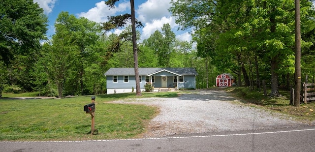 5070 Ridge Rd, Joelton, TN 37080 - view of front of property featuring gravel driveway, covered porch, a storage unit, an outbuilding, and a front yard