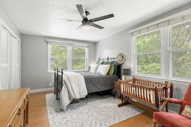 5070 Ridge Rd, Joelton, TN 37080 - bedroom with a textured ceiling, light wood-style floors, a ceiling fan, and baseboards