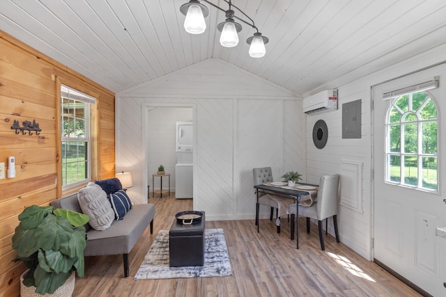 10931 Beechcraft Rd, Bon Aqua, TN 37025 - interior space featuring stacked washer / drying machine, wood walls, wood finished floors, vaulted ceiling, and electric panel