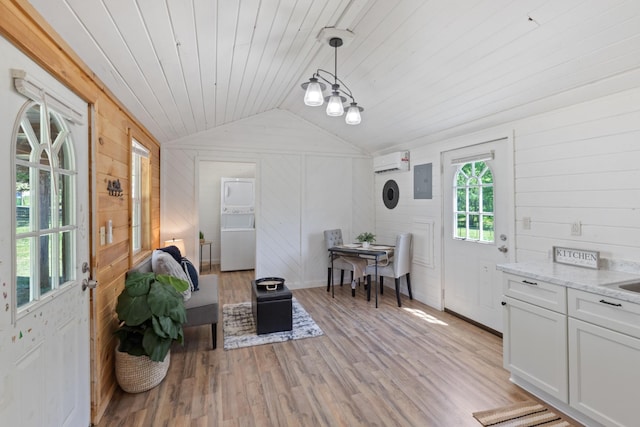 10931 Beechcraft Rd, Bon Aqua, TN 37025 - interior space with an AC wall unit, light wood-style flooring, wooden ceiling, vaulted ceiling, and stacked washer and clothes dryer