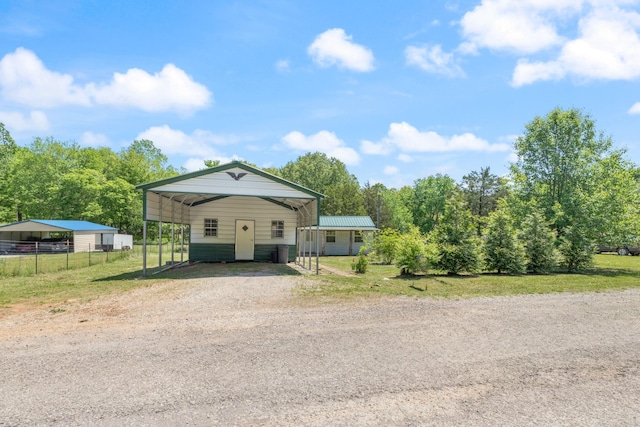 10931 Beechcraft Rd, Bon Aqua, TN 37025 - view of front of home with fence, a front lawn, a carport, driveway, and metal roof