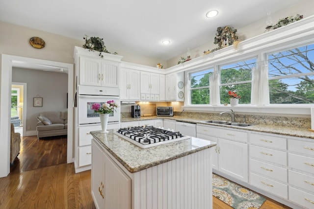 1494 Grant Rd, Watertown, TN 37184 - kitchen featuring a sink, white appliances, a center island, white cabinetry, and light wood-type flooring