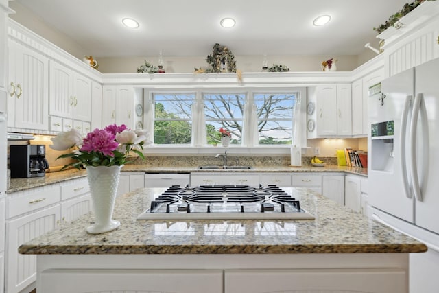 1494 Grant Rd, Watertown, TN 37184 - kitchen featuring a center island, a sink, light stone counters, white cabinets, and white appliances