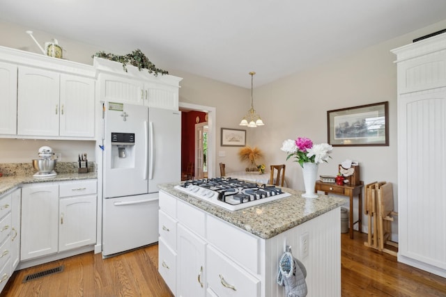 1494 Grant Rd, Watertown, TN 37184 - kitchen with white appliances, white cabinetry, a kitchen island, and light wood-type flooring