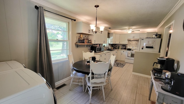 4471 Seminary Rd, Smyrna, TN 37167 - dining room featuring a textured ceiling, washing machine and dryer, visible vents, ornamental molding, and ceiling fan with notable chandelier