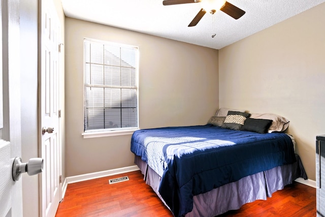 bedroom with wood finished floors, baseboards, and ceiling fan