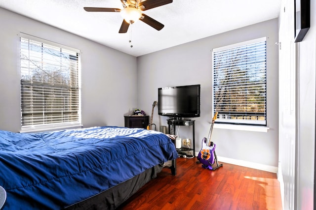 bedroom with wood finished floors, baseboards, and ceiling fan