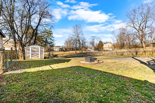 view of yard featuring an outdoor fire pit, a storage unit, and an outdoor structure
