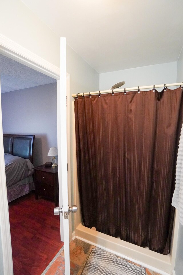 full bath with a shower with shower curtain and wood finished floors