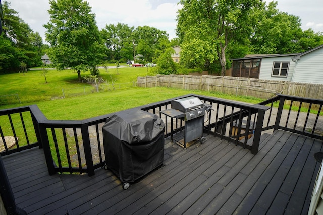 wooden terrace with area for grilling and view of scattered trees
