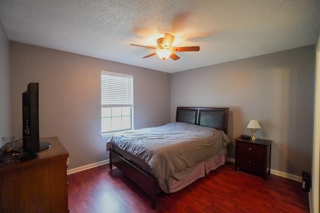 bedroom with dark wood-type flooring, baseboards, a textured ceiling, and ceiling fan