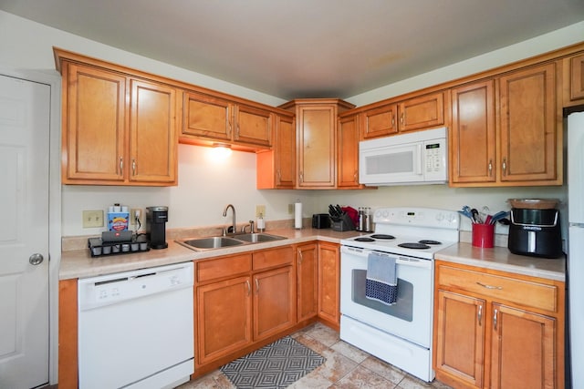 kitchen with white appliances, a sink, light countertops, and brown cabinets