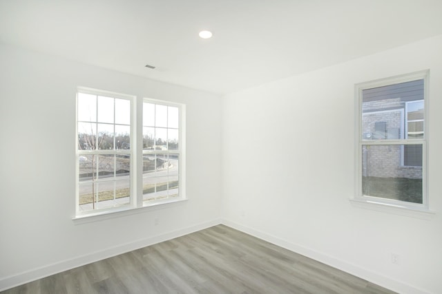unfurnished room featuring baseboards, recessed lighting, and light wood-style flooring