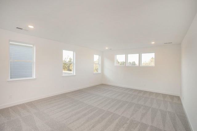 spare room featuring visible vents, recessed lighting, baseboards, and light carpet