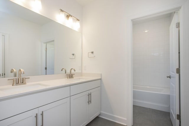 bathroom with double vanity, a sink, and baseboards
