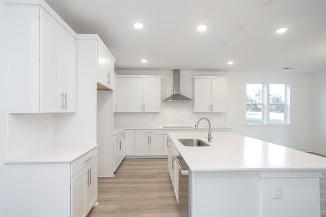 kitchen with recessed lighting, a sink, wall chimney exhaust hood, backsplash, and stainless steel dishwasher