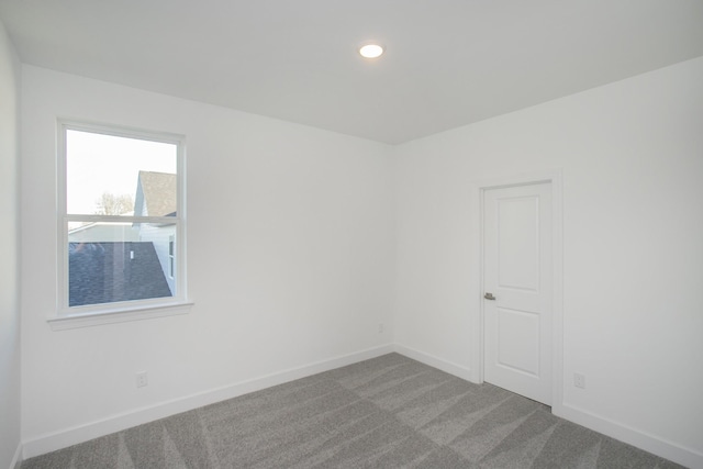 carpeted empty room featuring recessed lighting and baseboards