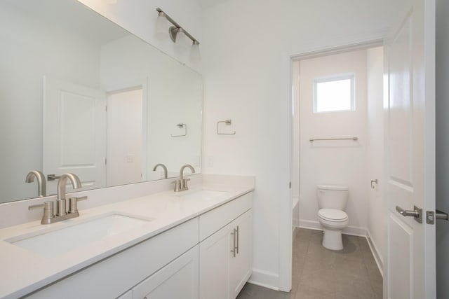 bathroom with baseboards, toilet, and a sink
