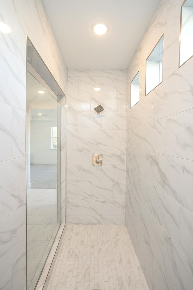 full bath with a healthy amount of sunlight and a tile shower