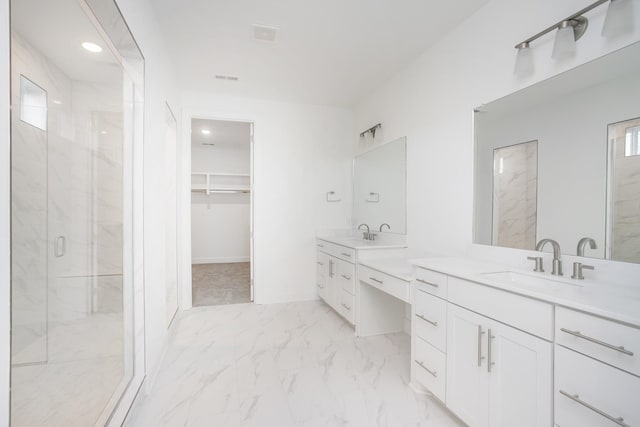 full bathroom with a sink, a marble finish shower, two vanities, marble finish floor, and a walk in closet