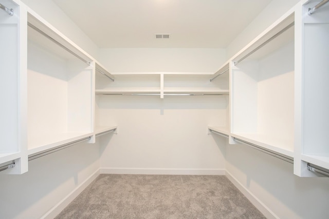 walk in closet with visible vents and light carpet