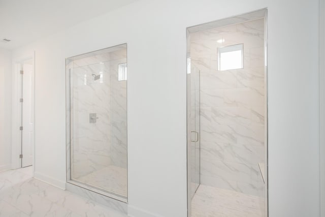 full bath with a marble finish shower, marble finish floor, and baseboards