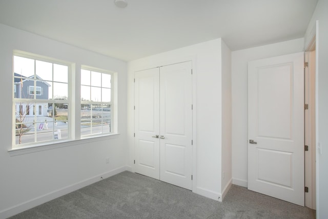 unfurnished bedroom featuring a closet, carpet flooring, and baseboards