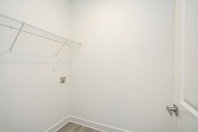 laundry room featuring wood finished floors, washer hookup, laundry area, and baseboards
