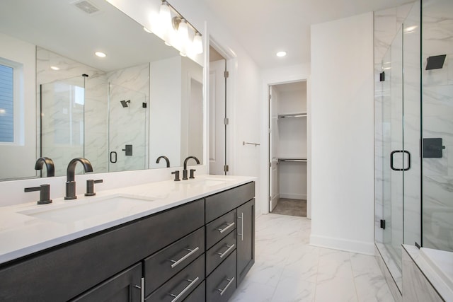 full bathroom featuring visible vents, a spacious closet, marble finish floor, and a sink