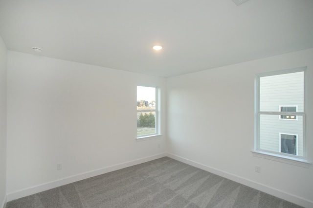 spare room featuring baseboards, recessed lighting, and light colored carpet