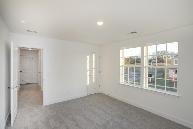 spare room featuring carpet floors, visible vents, recessed lighting, and baseboards