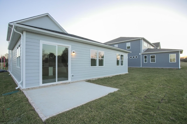 back of property with a lawn and a patio area