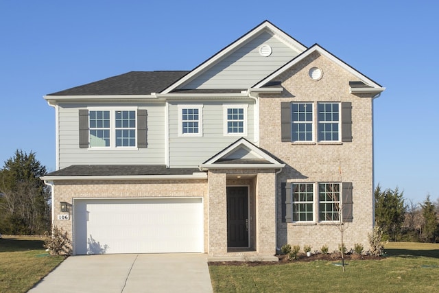 traditional-style home featuring driveway, roof with shingles, a front lawn, and a garage