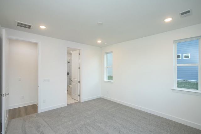 spare room featuring carpet, visible vents, recessed lighting, and baseboards