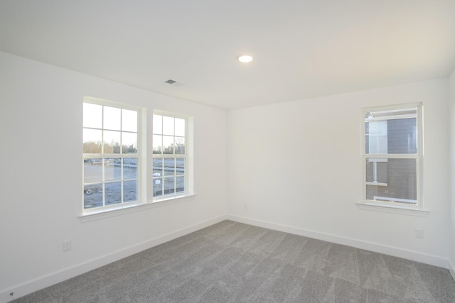 carpeted empty room with recessed lighting, visible vents, and baseboards