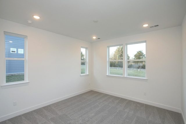 carpeted spare room with recessed lighting, visible vents, and baseboards