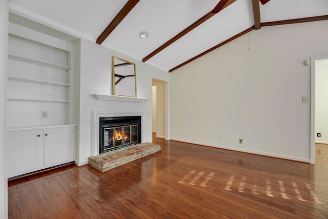 1202 General George Patton Rd, Nashville, TN 37221 - unfurnished living room featuring vaulted ceiling with beams, hardwood / wood-style flooring, built in features, a glass covered fireplace, and baseboards