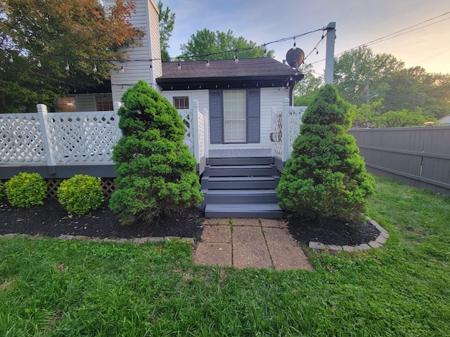 rear view of house featuring fence and a wooden deck