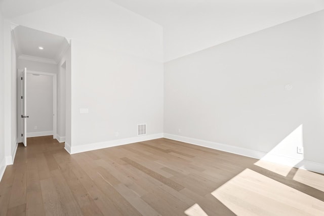 empty room featuring baseboards, visible vents, and wood finished floors