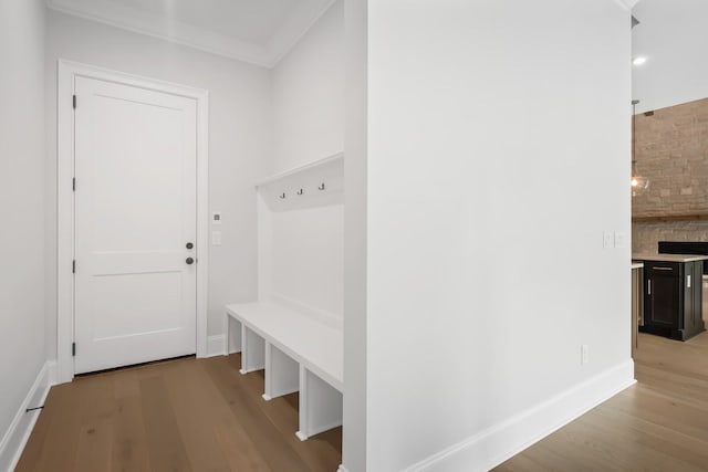 mudroom featuring light wood finished floors and baseboards