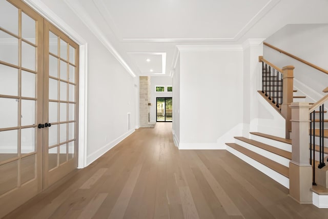 interior space featuring stairway, wood finished floors, baseboards, ornamental molding, and french doors