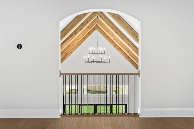 interior space featuring beamed ceiling, an inviting chandelier, and baseboards