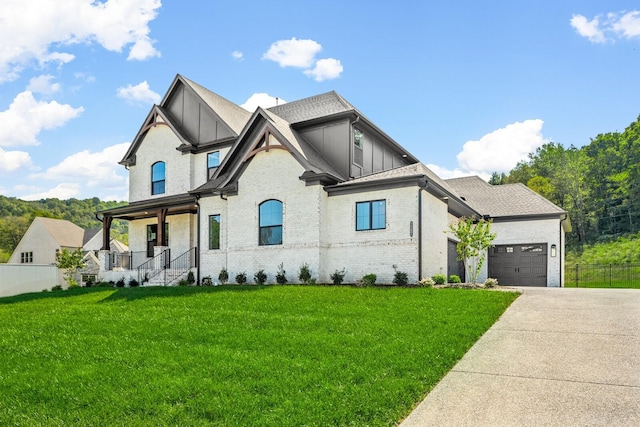 modern farmhouse featuring brick siding, fence, a garage, driveway, and a front yard