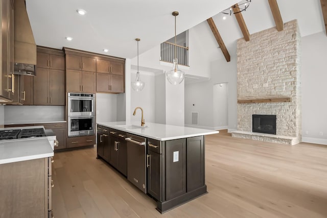 kitchen featuring light countertops, a sink, appliances with stainless steel finishes, and light wood-type flooring