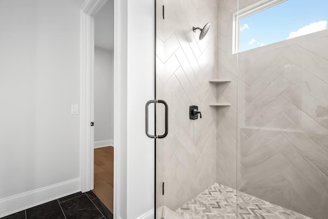 bathroom featuring baseboards and a shower stall