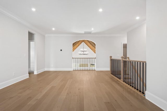 empty room featuring light wood-style floors, ornamental molding, and baseboards