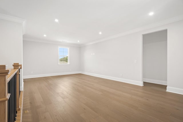 unfurnished living room featuring baseboards, light wood-type flooring, ornamental molding, and recessed lighting